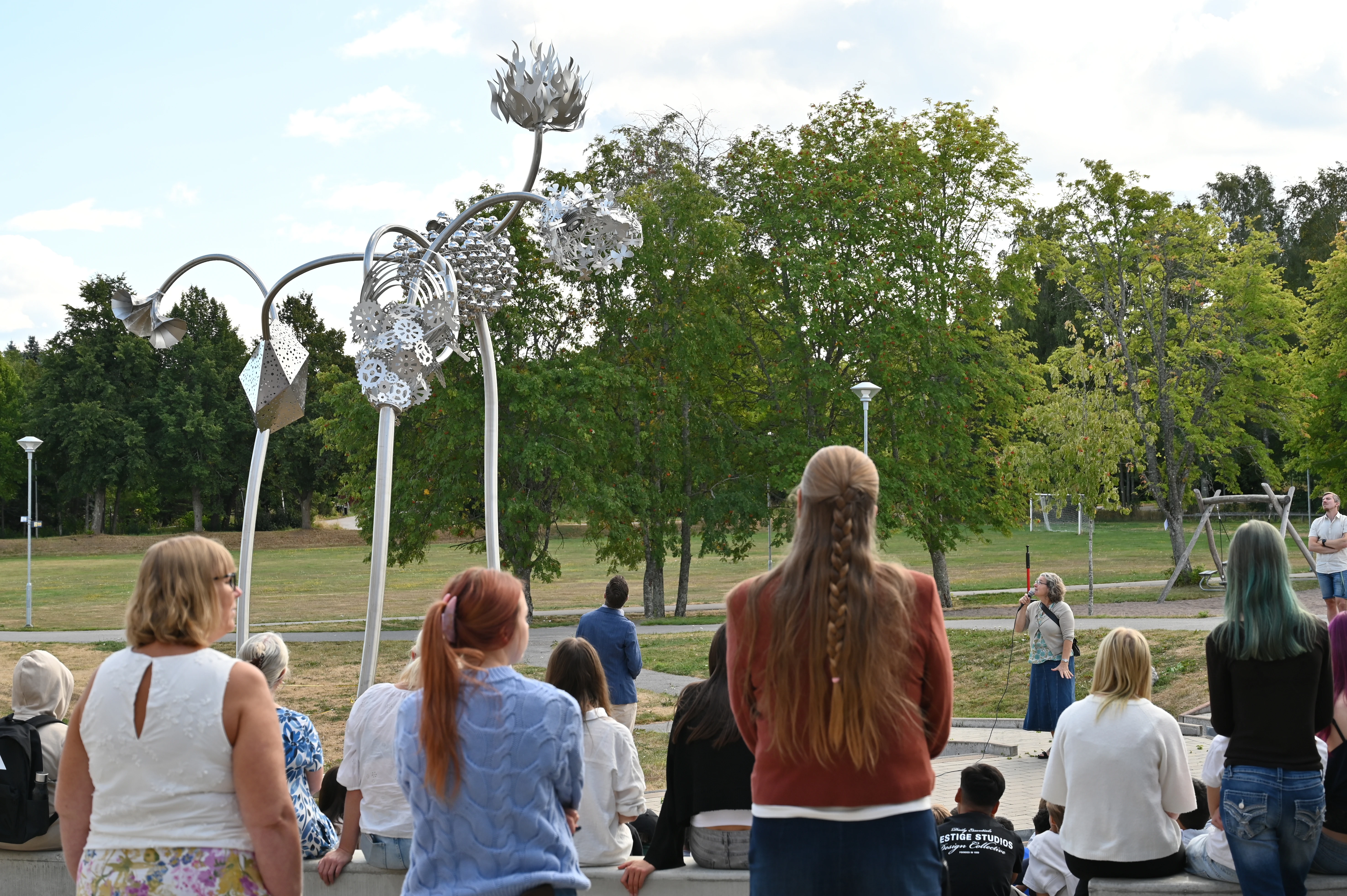 Publik samlad vid invigningen av konstverket Äventyrens element på Slottsskolans skolgård.